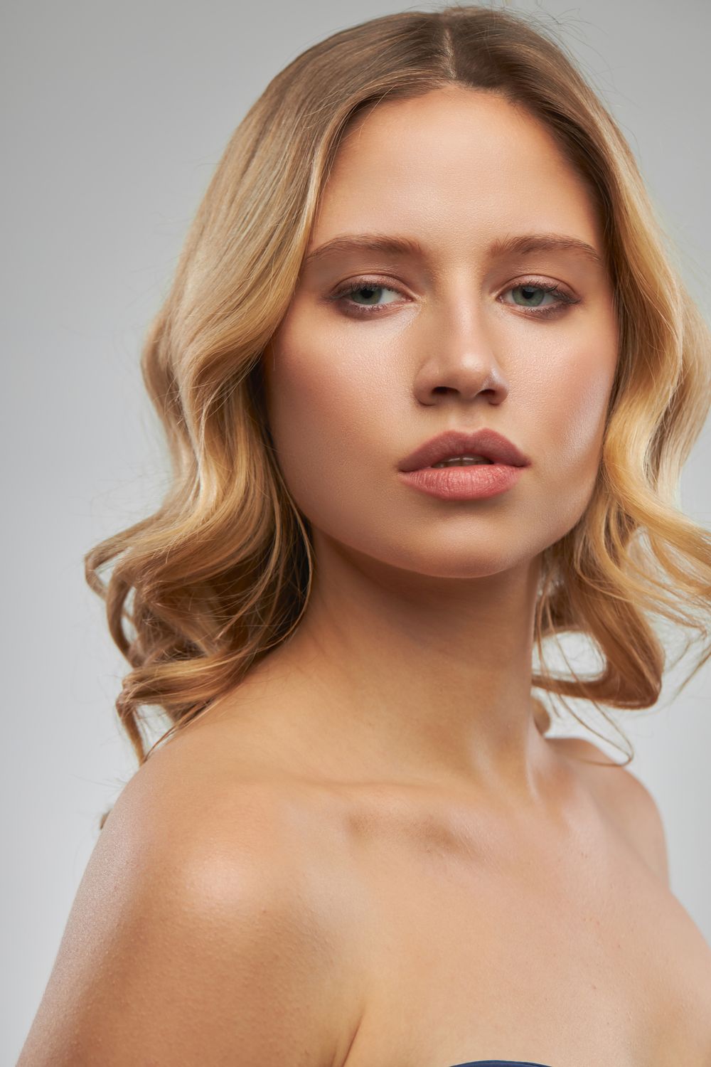 Model with wavy blonde hair and natural makeup.